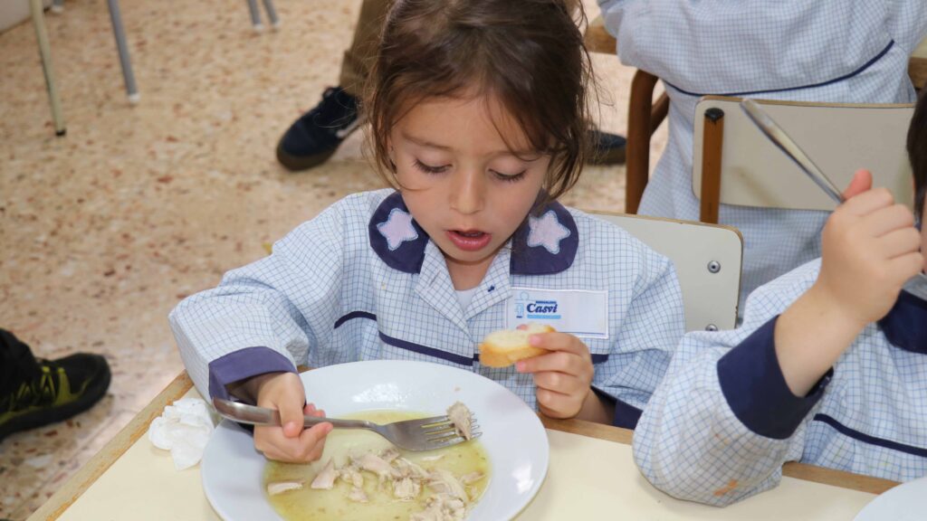 Niña comiendo pollo con patatas en el comedor de Casvi Villaviciosa.