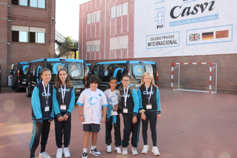 Estudiantes de primaria frente a bus en las instalaciones de colegio