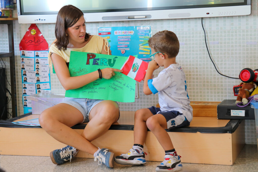 Alumno de infantil Casvi con una profesora viendo un cartel sobre Perú
