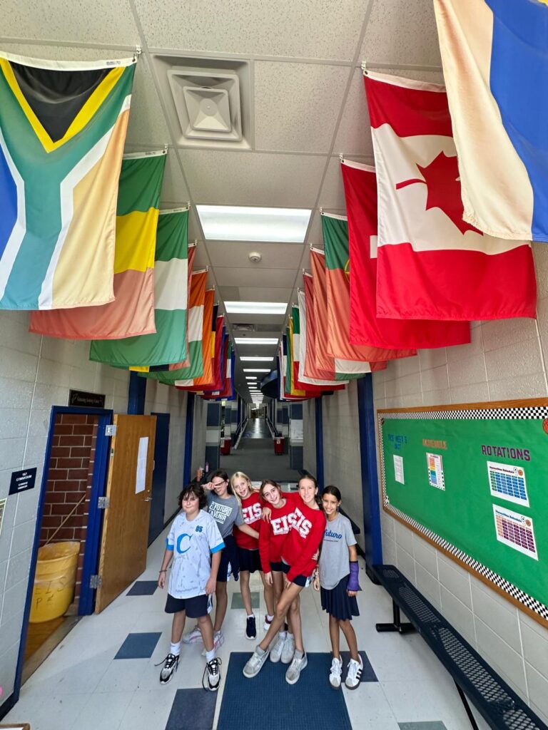 Niños en el pasillo con banderas de diferentes países en el techo