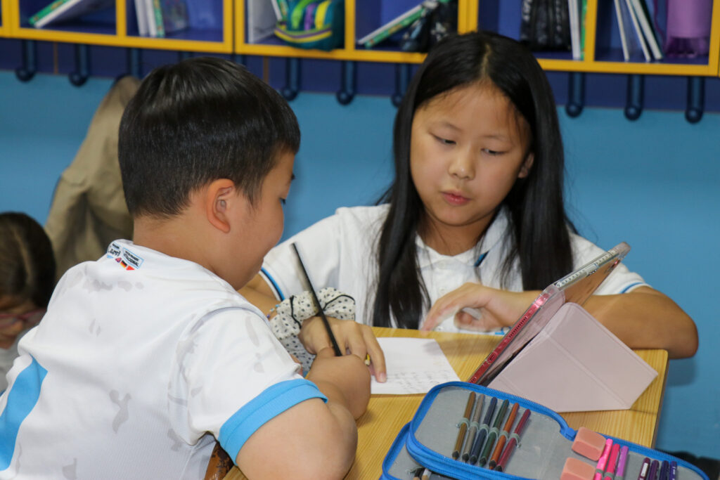 Dos niños escribiendo en papel